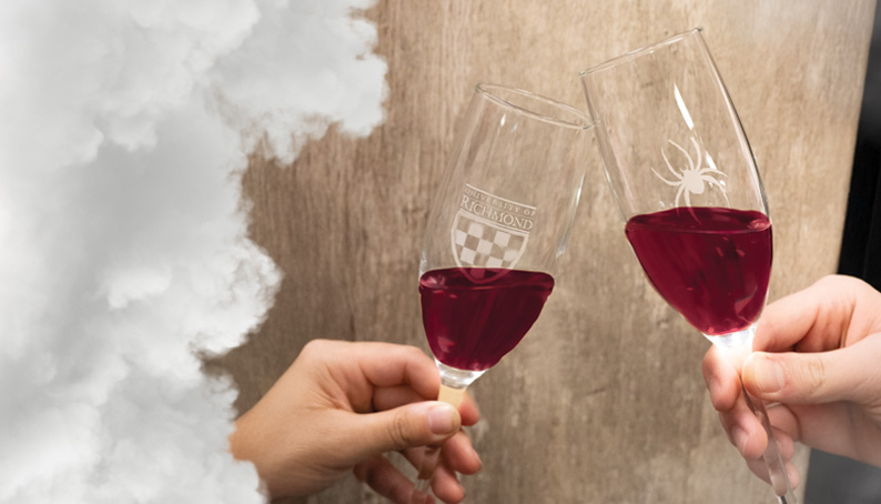 2 glasses with richmond logos etched on themtapping each other together